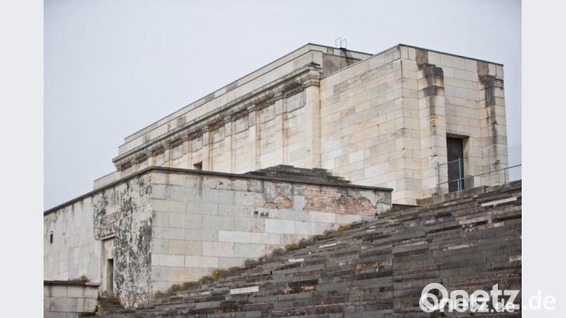 Rechtsextreme mit Fackeln haben auf der Zeppelintribüne in Nürnberg posiert. Das beobachteten auch Zivilpolizisten, die aber bei der Versammlung nicht einschritten. Bild: Daniel Karmann/dpa