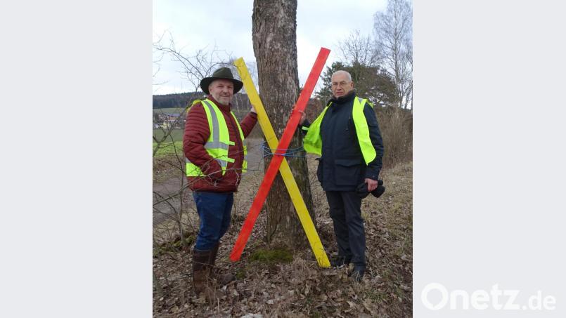 Alois Frank (links) und Josef Langgärtner stellen ein Mahnkreuz auf, es kommt erst weg, wenn die Trasse nicht kommt. Bild: Dobmeier