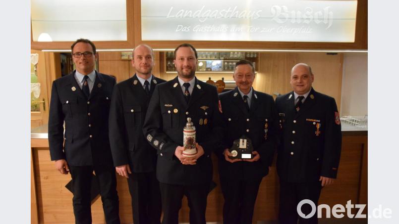 Sebastian Busch und Tobias Busch (Zweiter und Dritter von links) erhalten für 20-jährigen Feuerwehrdienst entsprechende Abzeichen. Kommandant Markus Nickl (rechts) ist seit 30 Jahren bei der Feuerwehr aktiv. An Christoph Pürner (Zweiter von rechts) übergibt Vorsitzender Peter Hautmann (links) eine Uhr mit Gravur für seine permanente Bereitschaft, Tobias Busch dankt er mit einem Krug für 10 Jahre als zweiter Kommandant. Bild: mde