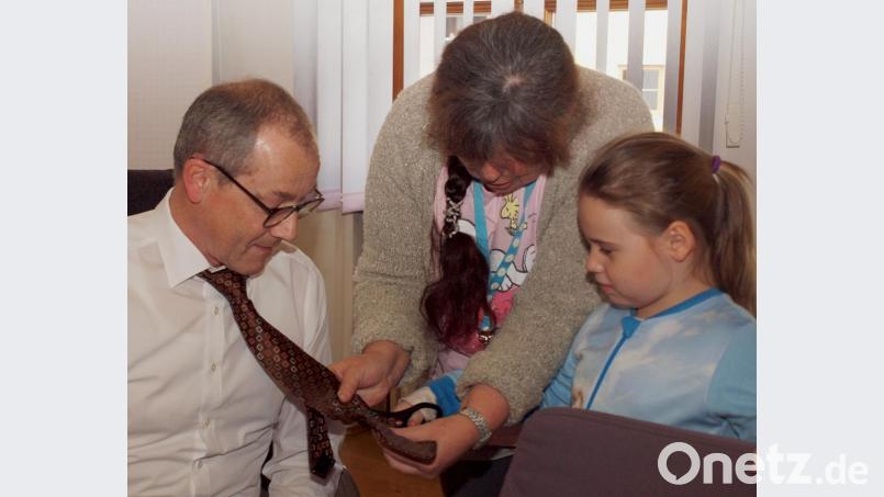 Kindergartenleiterin Doris Bruckner verleitete die kleine Sara dazu, Bürgermeister Erwin Geitner die Krawatte abzuschneiden. Bild: sön