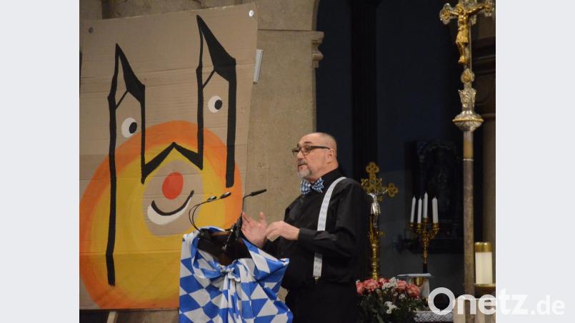 Zwischen Kreuz und einer lachenden Josefskirche erzählt Winfried Bühner von einer Pfarrwallfahrt nach Rom. Bild: Kunz
