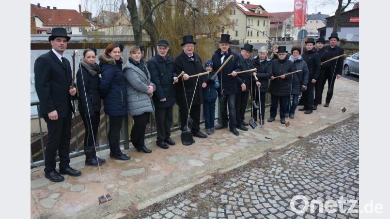 In Trauerkleidung trafen sich die Verantwortlichen der Faschingsvereinigung und des Mitterteicher Gaudiwurms mit Bürgermeister Roland Grillmeier (Mitte) zum traditionellen Geldbeutelwaschen auf der Färberbrücke. Bild: jr
