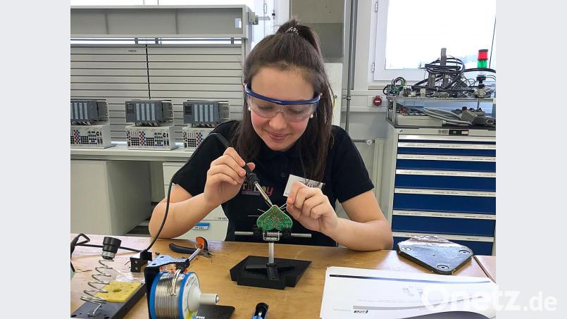 Sehr geschickt im Umgang mit dem Lötkolben: Eine der Teilnehmerinnen bestückt in der Werkstatt ein Herz mit LEDs. Bild: Peter Ringeisen/exb