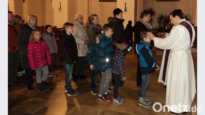 Diakon Dominikus Hartmann zeichnet mit geweihter Asche das Kreuz auf die Stirn Bild: ksi