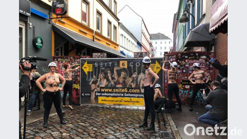 Mit nacktem Oberkörper und einer Flex demontieren Aktivistinnen im Rotlichtviertel von St. Pauli einen Sichtschutz der Herbertstraße. Bild: Carina Lue