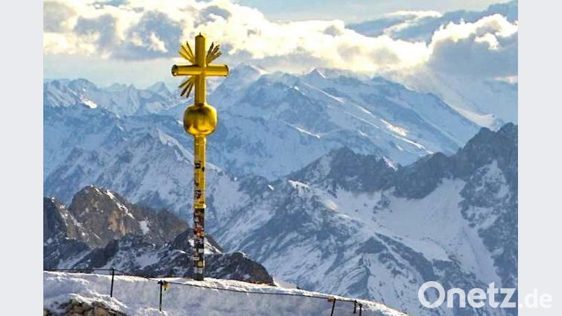 Das Gipfelkreuz auf der Zugspitze, an dem rechts unten einige vergoldete Strahlen abgebrochen sind. Foto: Bayerische Zugspitzbahn Bild: -