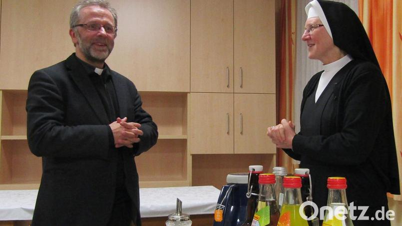 Pfarrer Markus Wittal bei der Annahme des Buchgeschenks von Provinzoberin M. Lucilla Hauser Bild: sck