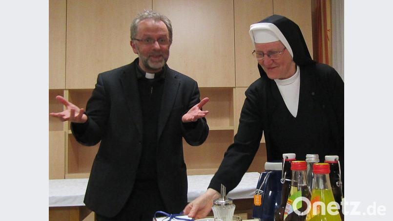 Pfarrer Markus Wittal bei der Annahme des Buchgeschenks von Provinzoberin M. Lucilla Hauser Bild: sck