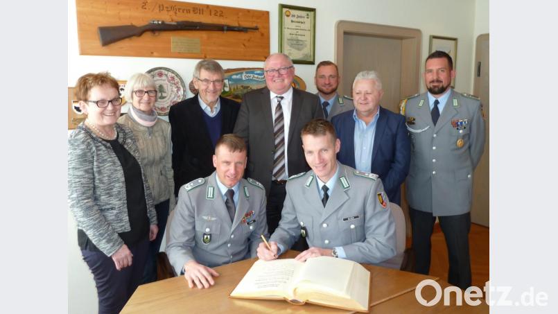 Oberstleutnant Christoph Huber (links) und der neue Kommandeur Andreas Bleek tragen sich in das Goldene Buch ein. Bürgermeister Heinz Weigl (Mitte) und seine Stellvertreter Christa Zapf (Zweite von links) und Peter Forster (Zweiter von rechts) sowie Barbara Ruhland und Josef Lohrer von den Stadtratsfraktionen schauen dabei über die Schulter, sowie auch Oberstabsfeldwebel Lars Piller (rechts) und Oberleutnant Steven Bussemer. Bild: Portner