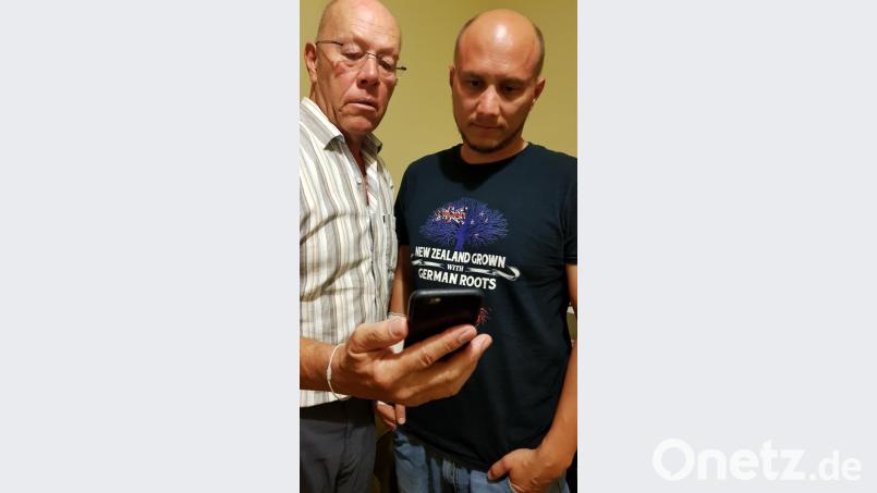 Gerhard (links) und Andreas Götz verfolgen auf dem Handy die Nachrichten zum Anschlag in Christchurch. Bild: Gerhard Götz