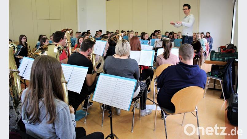 Dirigent Andreas Sächerl (stehend) schwingt den Taktstock Bild: stg