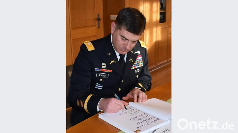 Colonel William Glaser trägt sich in das Goldene Buch der Mittelschule ein. Bild: rgr