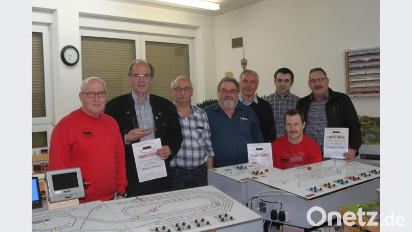 Vorsitzender Robert Beer (links) gratuliert den Geehrten der Modelleisenbahnfreunde. Bild: wrt