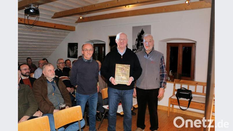 Der Vorsitzende der Gesellschaft „Steinwaldia“ Pullenreuth, Norbert Reger (rechts), dankte Hobbyfotograf Siegfried Steinkohl (stehend, links) für eine grandiose Bilderschau und zeichnete Jochen Weidner (Zweiter von rechts) als Gewinner eines Bilderrätsels aus. Bild: bsc