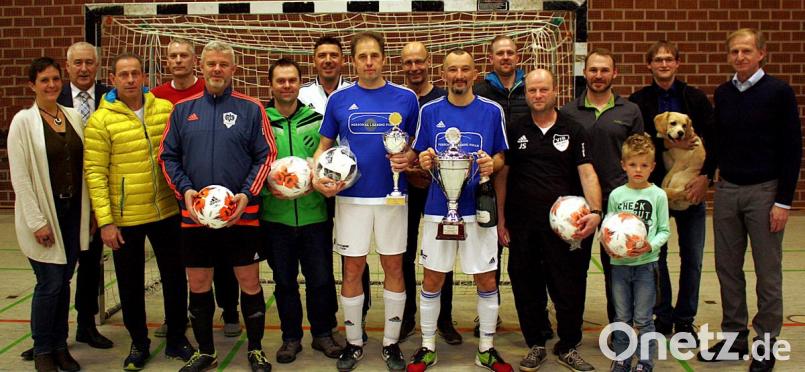 Die SpVgg Schirmitz (vorne) erhält von Präsident Karlheinz Ach (rechts) den Wanderpokal sowie eine Trophäe für den Pokalschrank. Die Mannschaftsführer der Teams bekommen einen Ball. Bild: R. Kreuzer