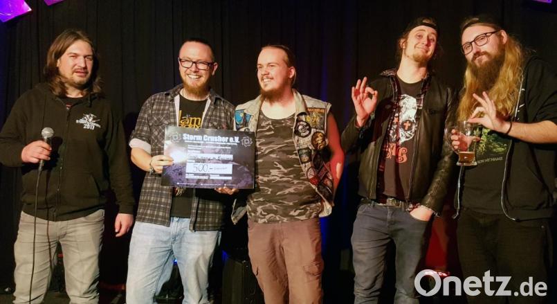 „God’s Away On Business“, die Lokalmatadoren aus Schwandorf, setzen sich beim „Band Crusher“-Contest im „Salute“ durch, „Storm Crusher“-Vorsitzender Matthias Gmeiner (links) ehrt die Sieger. Bild: lst