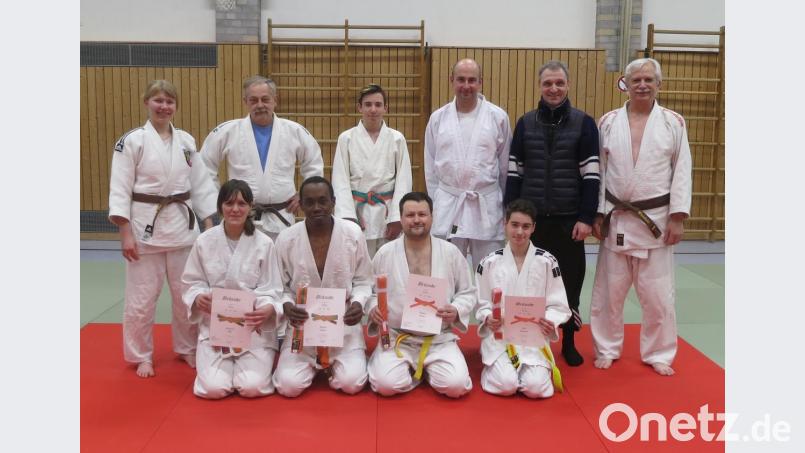 Thomas Kraus übergibt Helmut Rupprecht (hinten, Zweiter und Dritter von rechts) sowie (vorne, von links) Katharina Uhl, Matthew Milfort, Luca Rupprecht und Thomas Zaruba neue Gürtel. Mit Trainer Larry Querfurth (hinten, Zweiter von links) freuen sich auch die Übungspartner der Prüflinge über den Erfolg. Bild: rn