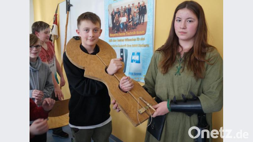 Beim Besuch der „Schwertbrecher“ erfuhren die Schüler unter anderem, wie es ist, in eine Schandgeige gesperrt zu sein. Bild: weu