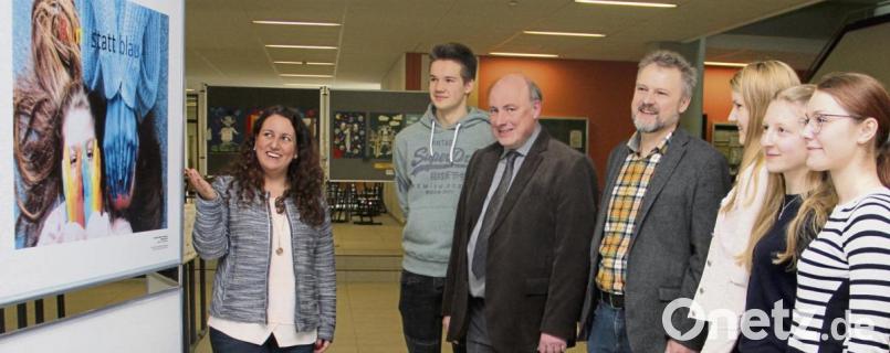 Caroline Schießl von der DAK Gesundheit (links), Schulleiter Georg Hecht (Dritter von links) und Kunstlehrer Helmut Völkl (Vierter von links) begutachten mit Schülern die Ausstellung. Bild: exb