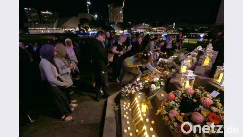 Teilnehmer einer Mahnwache legen Blumen für die Opfer des rassistisch motivierten Anschlags von Christchurch nieder. Foto: Kelly Barnes/AAP Bild: Kelly Barnes
