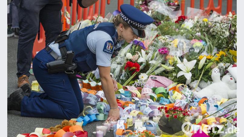 Eine Polizistin kniet am Ort einer Mahnwache im Hagley Park, in der Nähe der Al-Nur-Moschee in Christchurch. Bild: Pj Heller/ZUMA Wire/dpa