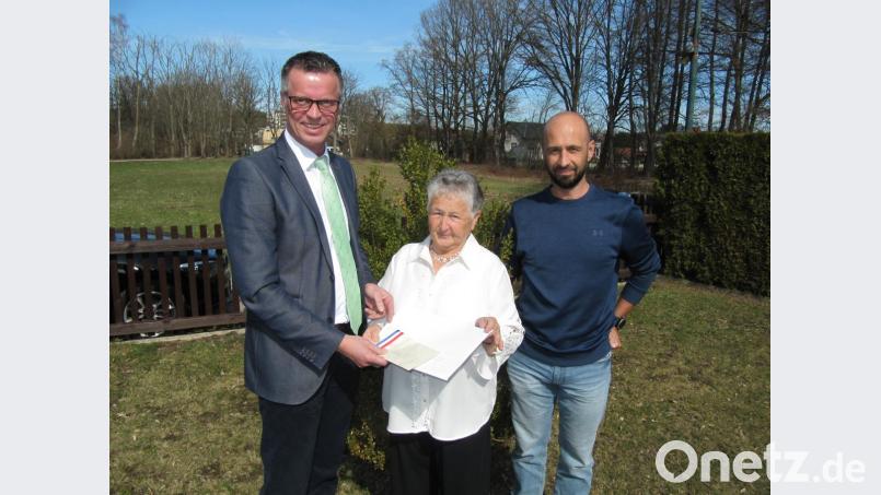Bürgermeister Hermann Falk (von links) gratuliert Gisela Witt, wo sie sich am wohlsten fühlt: draussen in der Natur. Mit dabei Sohn Alexander. Bild: fg