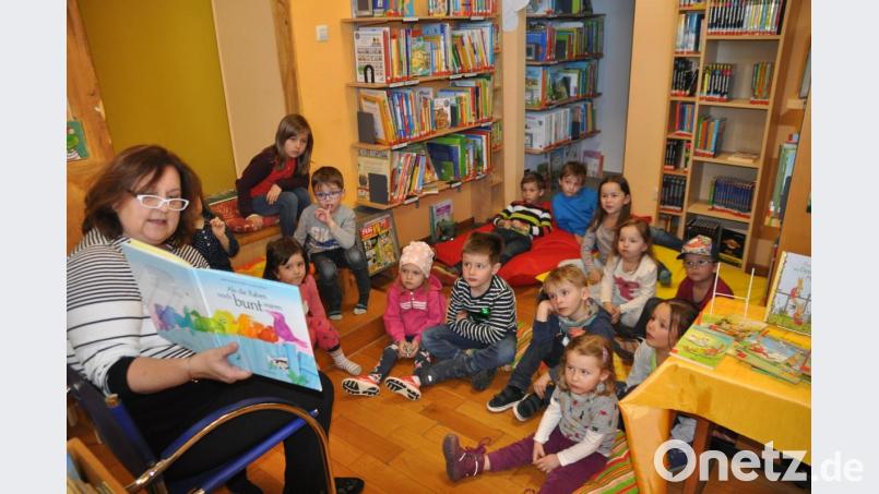 Wie kam es, dass die Raben ihre buntes Federkleid verloren? Sieglinde Lorenz (links) zeigt es den Mädchen und Buben. Bild: ak