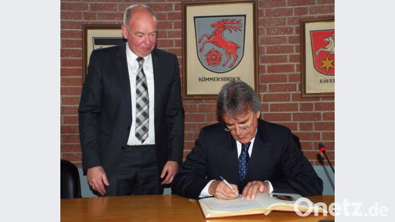 Regierungspräsident Axel Bartelt trägt sich ins Goldene Buch der Gemeinde Kümmersbruck ein. Links Bürgermeister Roland Strehl. Bild: e