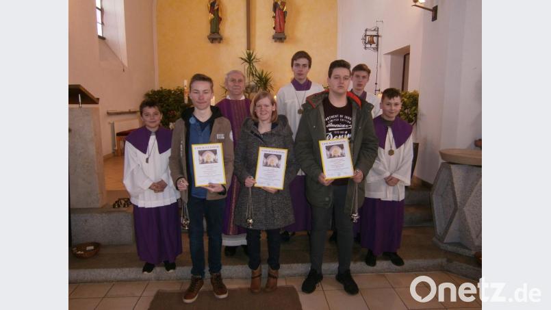 Jonas Rom, Eva Völkl und Alexander Pösl (von links) wurden aus dem Ministrantendienst in der Filialkirche St. Johannes Tröbes von Pfarrer Josef Most verabschiedet. Bild: gi