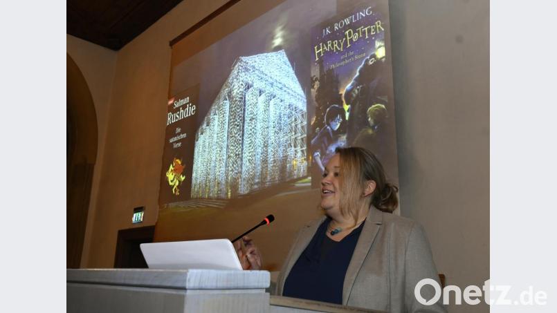 Ein Indiz dafür, dass Kinder- und Jugendliteratur immer etwas mit Wertevermittlung zu tun hat: Prof. Dr. Maren Conrad (Referentin) verweist darauf, dass „Harry Potter“ von Joanne K. Rowling bei der Documenta 14 im „Parthenon der verbotenen Bücher“ (im Hintergrund) gleich neben Salaman Rushdies „Die satanischen Verse“ hing. Bild: Hartl
