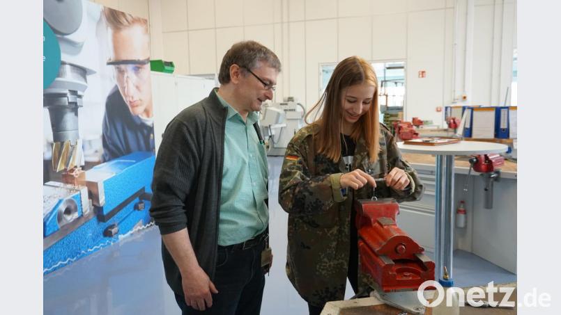 Ausbilder Franz Heininger blickt Laura Piehler über die Schulter. Sie ist gerade dabei einen Flaschenöffner aus Metall herzustellen. Bild: Christopher Dotzler