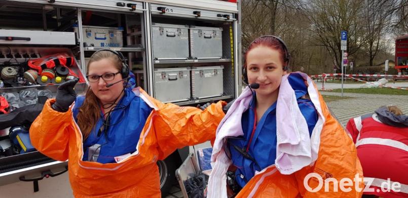 Patricia Oettl (links) und Susanne Staufer schlüpfen in die Schutzausrüstung vor dem Spezialfahrzeug der CBRNE-Fachgruppe. Bild: mde