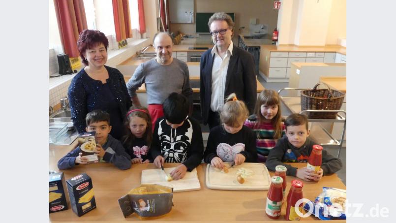 Zwiebeln schneiden: Auch das gehört zu den Vorbereitungen für die &quot;Lasagne al forno&quot;, die Cosimo Santoro (Mitte) mit einigen Schülern im Demokratie-Projekt &quot;Ich esse! Du isst! - Wir essen!&quot; kocht. Auch Wolfgang Bodensteiner (rechts), der Rektor der Markus-Gottwalt-Schule, und Angelika Trummer (links), gfi-Mitarbeiterin an der Offenen Ganztagsschule, lassen sich später das Gericht schmecken. Bild: rn