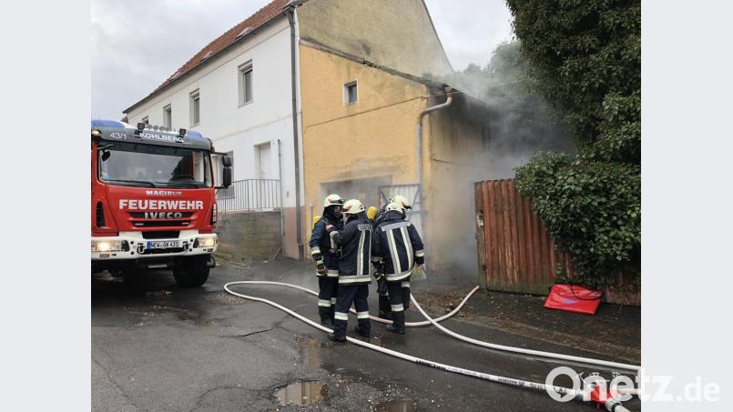 Aus dem Übungsobjekt raucht es. Die Feuerwehrmänner legen die Atemschutzgeräte an, um einen Innenangriff zu starten. Bild: Julian Fischer
