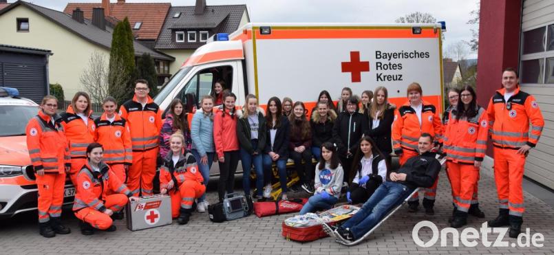 Nina Ruckdeschel, Patricia Hanny, Theresa Maurer, Lena Haubner, Philipp Hundhammer und Vicky Seiler (von links) mit den 16 Schülerinnen beim „Girls’ Day“ bei der BRK-Rettungswache Kemnath vor den Rettungsdienstfahrzeugen. Julian Dötterl, Daniela Hofmann, Annika Arnold und Melissa Pregler (von rechts) haben den „Tag als Notfallsanitäterin“ organisiert. Patrick Pfau (liegend) unterstützt den Ablauf. Bild: mde