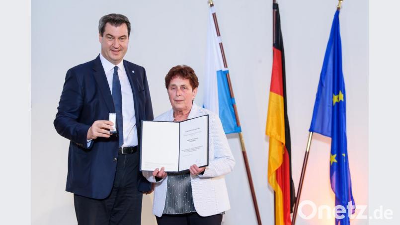 Bayerns Ministerpräsident Markus Söder übergibt Gretl Woppmann das Abzeichen des Bayerischen Ministerpräsidenten. Bild: Joerg Koch/Bayerische Staatskanzlei