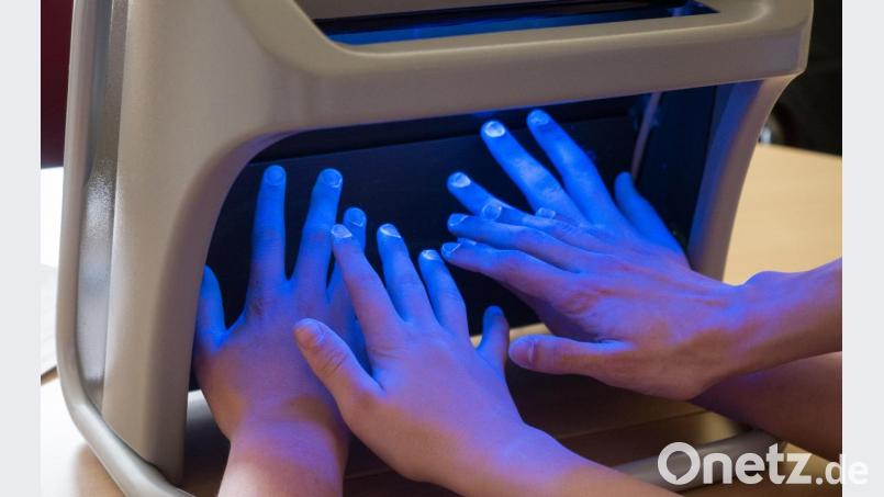 Im UV-Licht kann Hygienefachkraft Sabine Fischer genau erkennen, wie effektiv sich jemand die Hände desinfiziert hat. Bild: tr