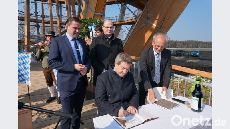 Markus Söder (sitzend) trägt sich ins Goldene Buch der Gemeinde ein. Bild: Christopher Dotzler