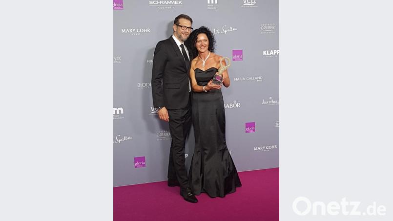 Laudator Kai Wiesinger überreicht Berta Schmidt aus Amberg die Gloria-Trophäe für den ersten Platz in der Kategorie „Kosmetikinstitut bis zwei Mitarbeiter“. Bild: exb