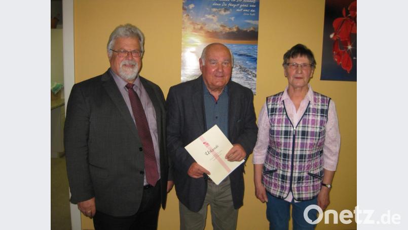 Pfarrer Arnold Pirner (links) und KAB-Betreuerin Helga Goschler zeichnen Josef Meiler mit Urkunde und Nadel für 40 Jahre Mitgliedschaft bei der KAB aus. Bild: exb