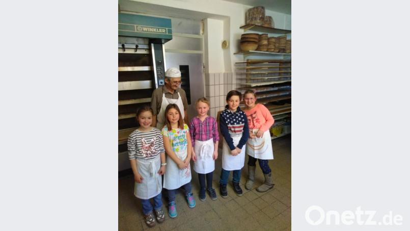 Bäckermeister Josef Reichenberger führt die Kommunionkinder durch seine Backstube, in der sie auch selbst Brote backen dürfen. Bild: hl