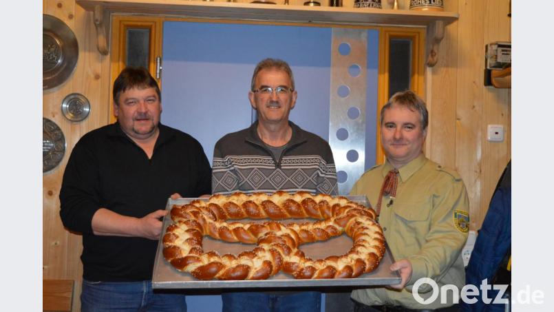 Vorsitzender Hans Mösbauer (rechts) und sein Stellvertreter Markus Fichtinger (links) bedankten sich beim noch amtierenden Schützenkönig Günther Nirschl für die leckere Riesenbreze. Bild: bej