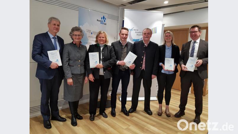 Im Münchner Presseclub präsentieren Behördenvertreter und Redaktionsmitglieder - (von links) Ministerialdirektor Herbert Püls, Ingrid Ritt, Karin Oechslein, Stefan Schießl, Ludwig Schießl, ISB-Referentin Christina Neugebauer und Ministerialrat Peter Kammler die druckfrische "Handreichung" zur Dialektpflege im Schulunterricht. Bild: slu