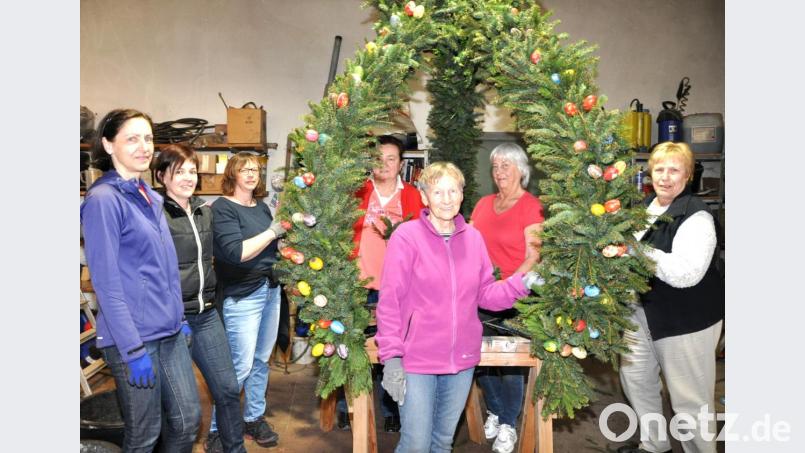 Sabine Winkler (Dritte von links) hat die Aktion organisiert. Mit Fichtenstreu aus dem geologischen Lehrpfad und Thujen von der Familie Kick in der Kleinschwandner Straße schmücken die Siedler die Osterkrone im Bauhof. Bild: es