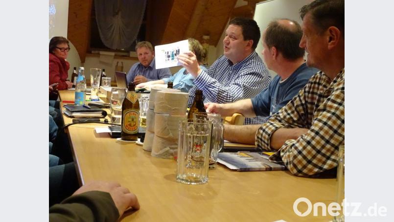 Letzter Organisatorentreff vor dem großen Fest: Bürgermeister Christian Ziegler hat Bilder von Bands und Kapellen dabei, die am ersten Maiwochenende in Wolfring auftreten. Bild: Houschka