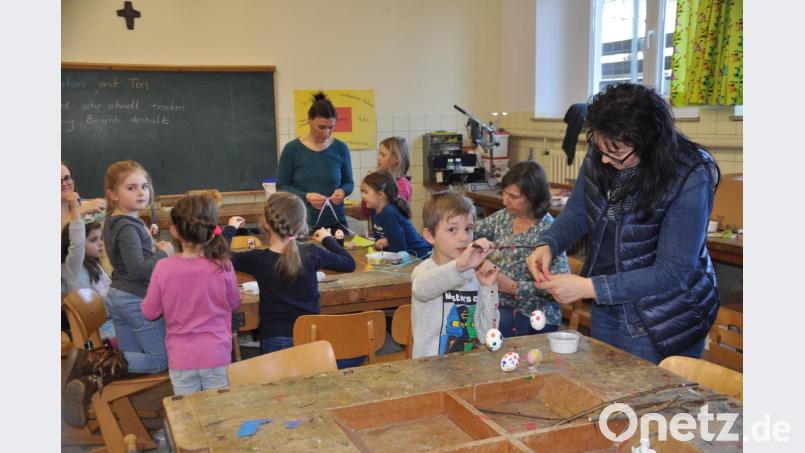 Beim Auffädeln und Befestigen der bemalten Ostereier braucht es manchmal noch die Hilfe der Büchereimitarbeiterinnen. Bild: ak