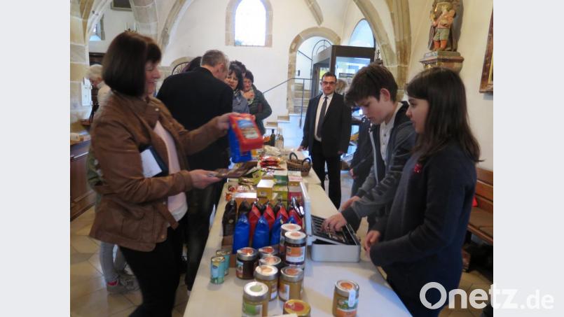Beim Firmprojekt „Transfair-Warenverkauf“ bieten einige Firmlinge mit Gemeindereferent Jochen Gößl Transfair-Waren zum Kauf an. Bild: jzk