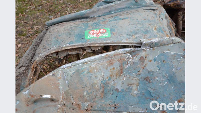Seltsame Aufkleber: Auf dem Käfer-Wrack kleben Sticker mit Sprüchen. Bild: ca