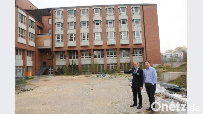 Vorstand Klaus Emmerich (links) und Vorstandsreferent Andreas Poeplau zeigen, wo die Zwischenlösung für die Küche hinkommt. Hier im Westen des Komplexes werden im Sommer wieder Container aufgestellt. Bild: ge