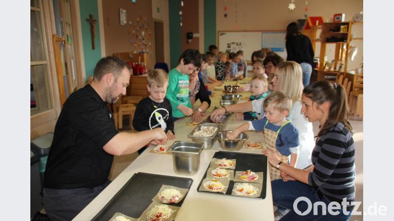 Unter der Anleitung von Kräuterkoch Andreas Meier (vorne links) durften die Kinder ihre Pizzas selbst belegen und natürlich dann essen. Das machte mächtig Spaß. Bild: frd